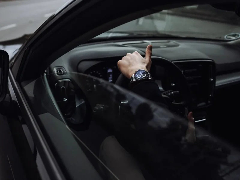 Driver's hand resting on the steering wheel