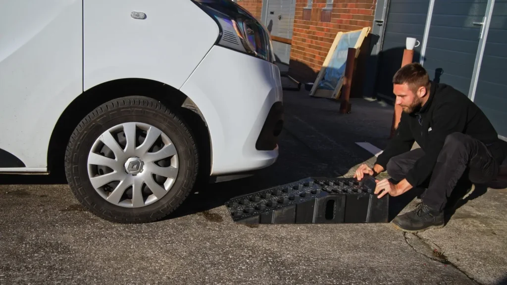 Technician working at the front of a van on a driveway