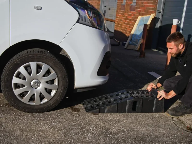 Technician working at the front of a van on a driveway